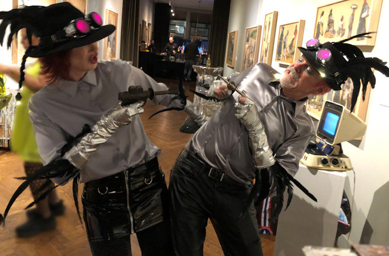 West Village model Karen Rempel and her pal Jeff Reid duel it out while joined at the hip at the National Arts Club’s 2023 Bonnet Bash, with props from Denny Daniels's Museum of Interesting Things. (Photo by Denny Daniels)