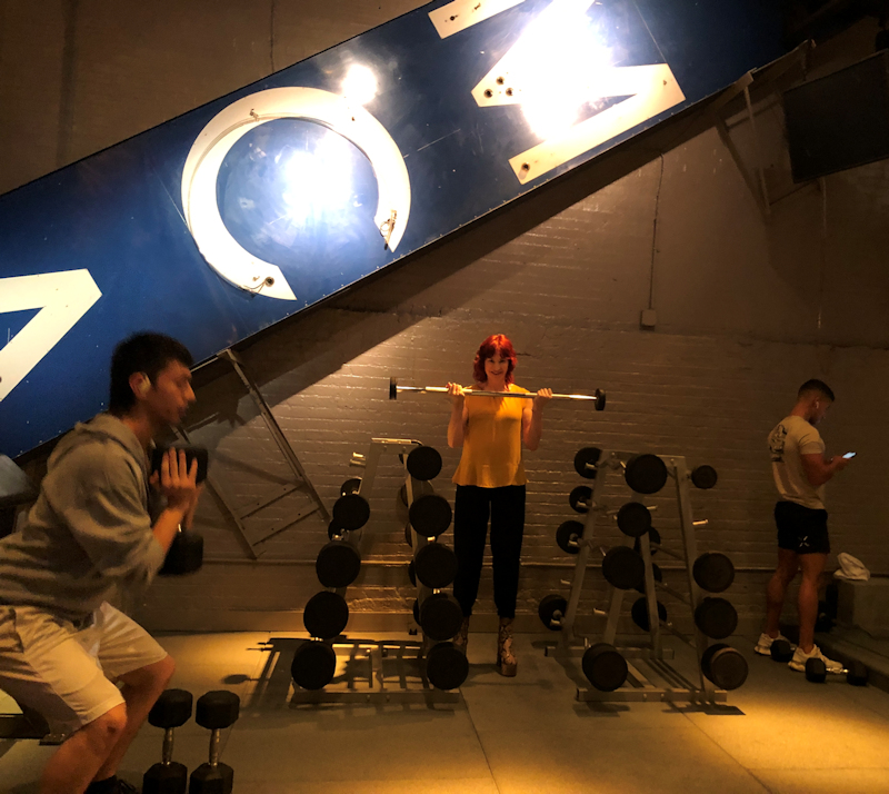 Manhattan model Karen Rempel pumps iron under the iconic YMCA sign