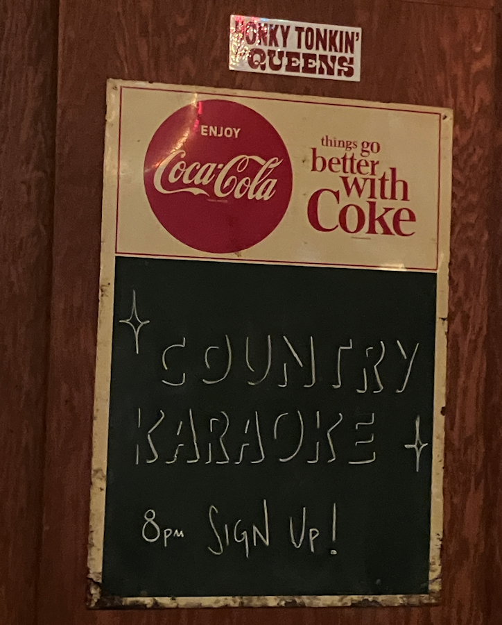 Chalk board sign up for country karaoke at 8 PM